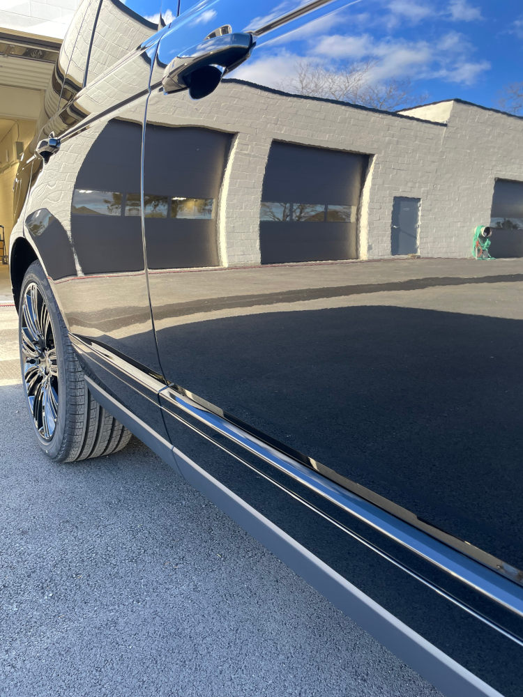 Shiny black car reflecting building - Paint Correction
